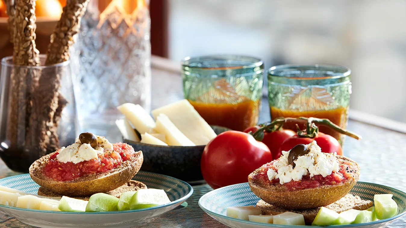 Local Cretan gastronomy with dakos, tomatoes, cheese, cucumber and drinks Local Cretan gastronomy with dakos, tomatoes, cheese, cucumber and drinks